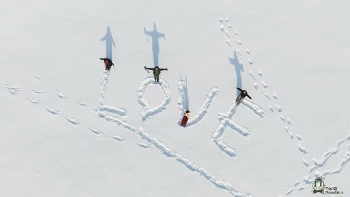 俯瞰雪地中的人物与写在雪上的 LOVE 字样